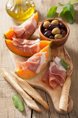 cantaloupe melon with prosciutto grissini olives. italian appeti