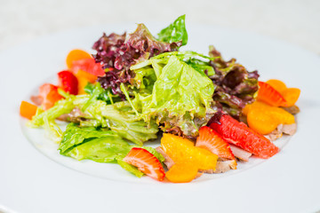 Fruit and vegetable salad on a white plate