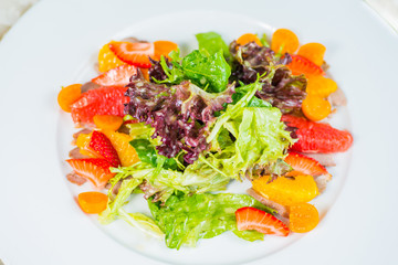 Fruit and vegetable salad on a white plate