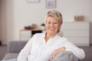 moderne, entspannte seniorin auf ihrem sofa - obrazy, fototapety, plakaty