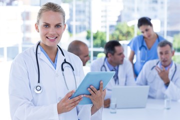 Smiling female doctor looking at clipboard