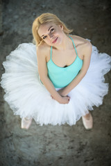 Pretty blond ballerina looking up at the camera. 