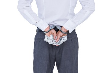 Wear view of businessman with handcuff and money in hands 