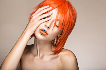 Beautiful girl in an orange wig cosplay style with bright creative lips. Art beauty image. Portrait...