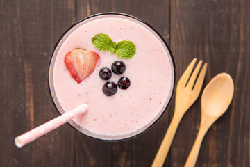 Blueberry and strawberry smoothie on wooden background.