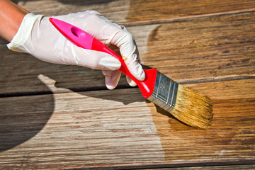 Applying protective varnish on a wooden furniture