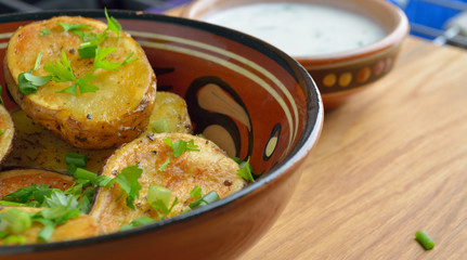 Roasted potato in bowl on wooden table