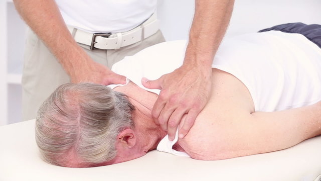 Doctor massaging his patients shoulders