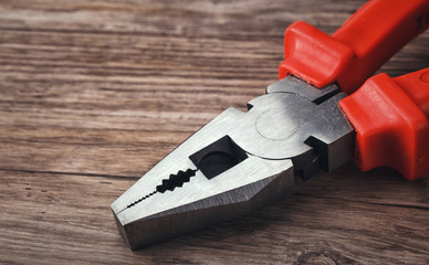 multitool pliers on wooden background