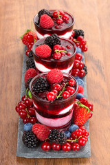 glasses with frozen dessert with mixed berries on wood table