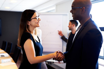 Female colleague shaking hands with male colleague