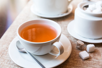 Cup of tea and tea pot on table