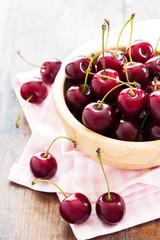 Fresh red cherries in bowl on a wooden table