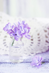 Fototapeta na wymiar Lilac flowers in a small glass bottle