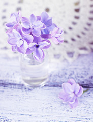 Lilac flowers in a small glass bottle