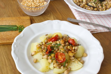 healthy vegan food - chickpeas, peas and lentils served with tomatoes and potatoes