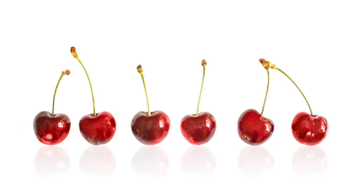 Row of cherries isolated on white background