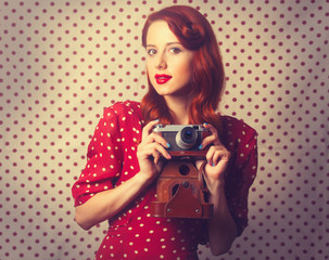 Portrait of redhead girl with retro camera