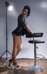 Beauty caucasian brunette with long legs posing near chair