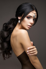 Naklejka premium Beautiful model brunette with long curled hair