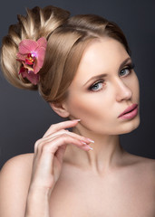 Fototapeta premium Portrait of a beautiful woman in the image of the bride with flowers in her hair. Picture taken in the studio on a black background