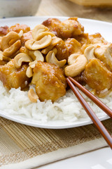 Asian Cashew Chicken – A plate of Chinese food, with white rice and cashew chicken. Chopsticks in the foreground.