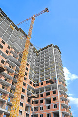 Fototapeta na wymiar Crane and building construction site against blue sky