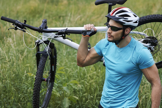 Well Built Man Carrying His Bike..