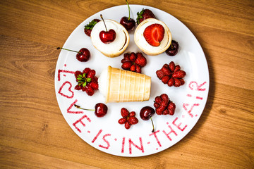 Ice cream with strawberry and cherry on a plate. Love is in the air.