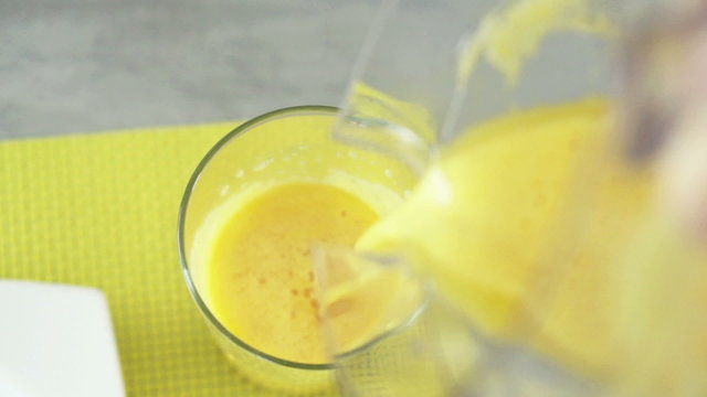 Pouring orange juice into glass, top view, slow motion shot at 240fps
