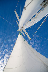 View of the sails and mast against the sky.