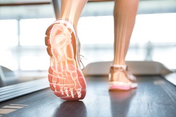 Fototapeta Highlighted foot of woman on treadmill obraz