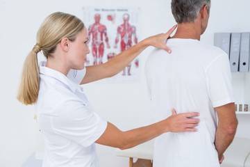 Obraz premium Doctor examining her patient back 