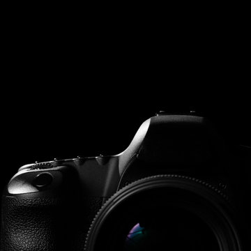 Digital image of a professional modern DSLR camera low key image. Modern DSLR camera with a very wide aperture lens on with highlights and shadows in square shape