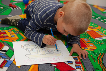 The boy draws pictures.