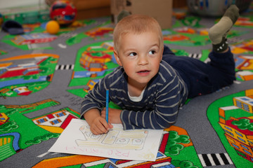 The boy draws pictures.