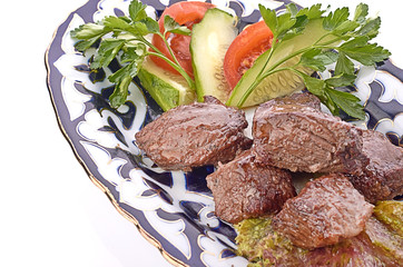 Meat on a grill with vegetables