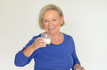 Seniorin trinkt ein Glas Milch