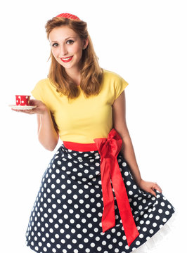 Frau im Rockabilly Style bietet eine Tasse Kaffee an