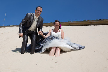 Newlywed couple  on the beach under blue sky