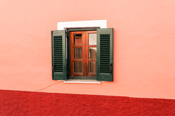  part of house in Corfu with a wooden green window.