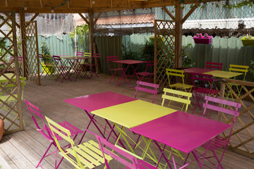 View of an empty outdoor cafe in yellow and pink