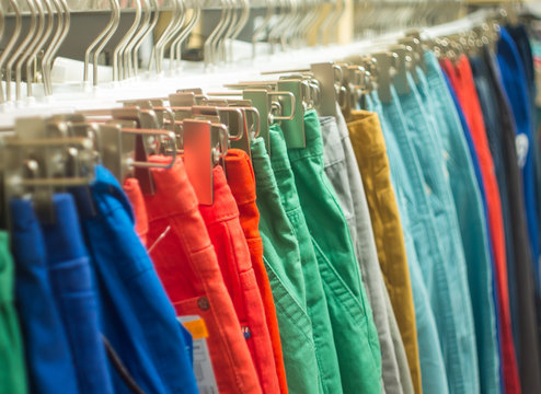Colorful hipster trousers hanging on sale in store