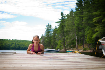 Fototapeta premium young teenage girl on a dock at a lake in Ontario's cottage country