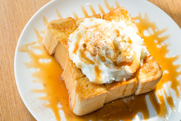 Golden honey toast in the white dish with whipped cream on top