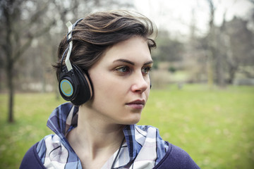 Woman listening to music with headphones at the park