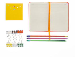 Notebook, pencil  and paper clips on white background
