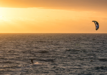 A man kitesurfing during a sunset in Indian ocean in Perth
