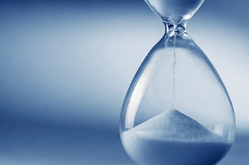 Hourglass clock on light blue background