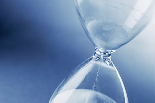 Hourglass clock on light blue background